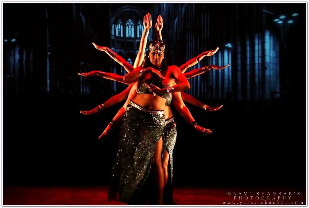 A group Tribal Fusion performance forming the silhouette of a many-armed figure